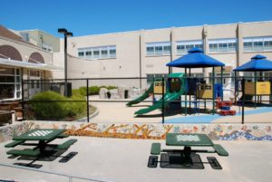 imagen del patio de recreo de la escuela harding con bancos y un mosaico en primer plano